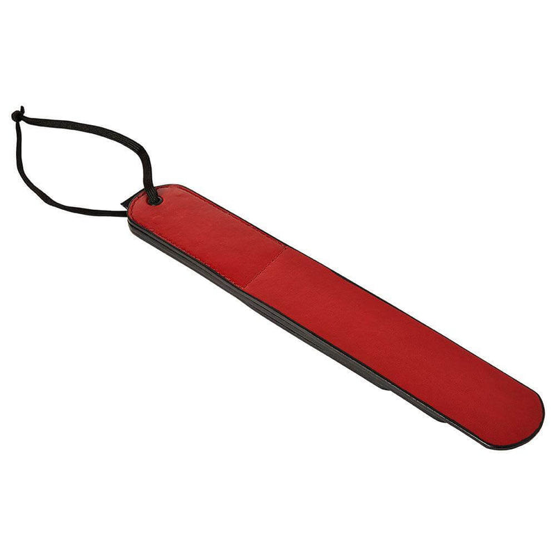 The Sportsheets Saffron Layer Paddle flipped upside down. The backside is a flat, red single layer of material. | Kinkly Shop