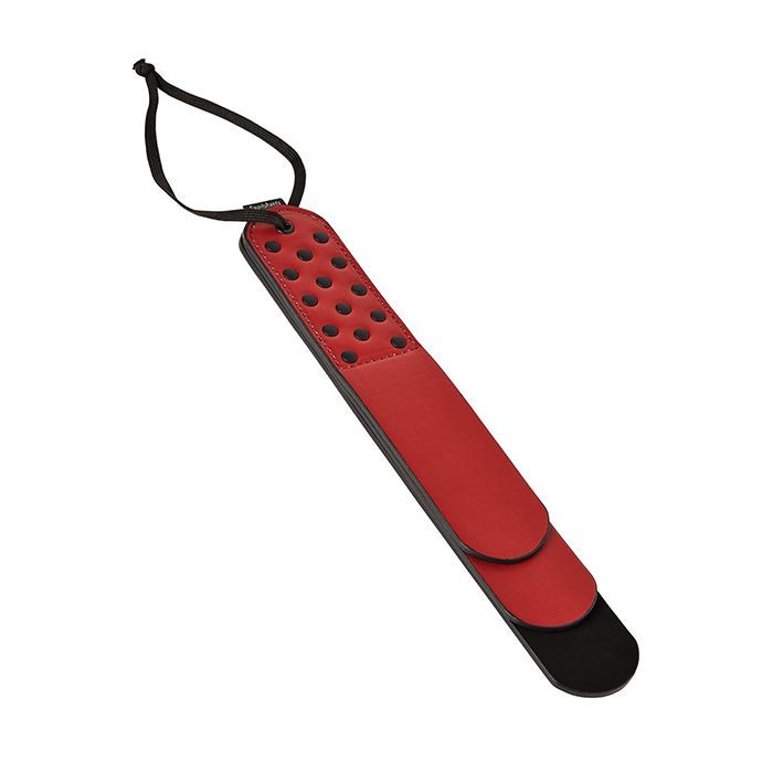 Sportsheets Saffron Layer Paddle against a white background. The paddle is a deep fire engine red with three different layers. It has black accent rivets that hold the multiple layers together as well as a wrist/hanging strap for storage and use. | Kinkly Shop