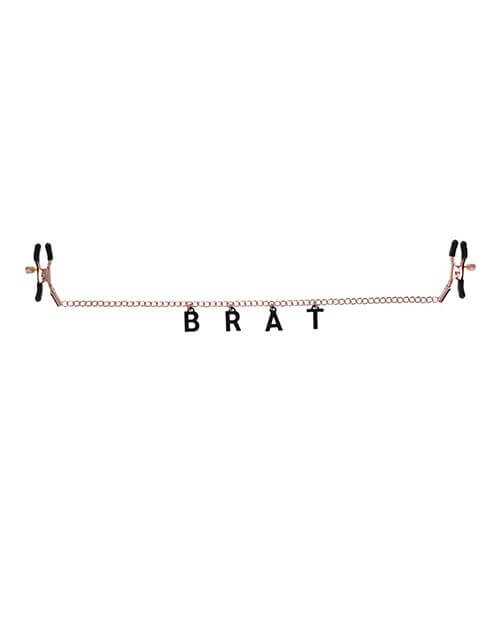 The Sportsheets Brat Charmed Nipple Clamps laid out flat on a plain white background. The "BRAT" letters are hanging off the chain that connects the two nipple clamps to one another. The letters aren't quite as big as the nipple clamps themselves, but they're very visible. | Kinkly Shop