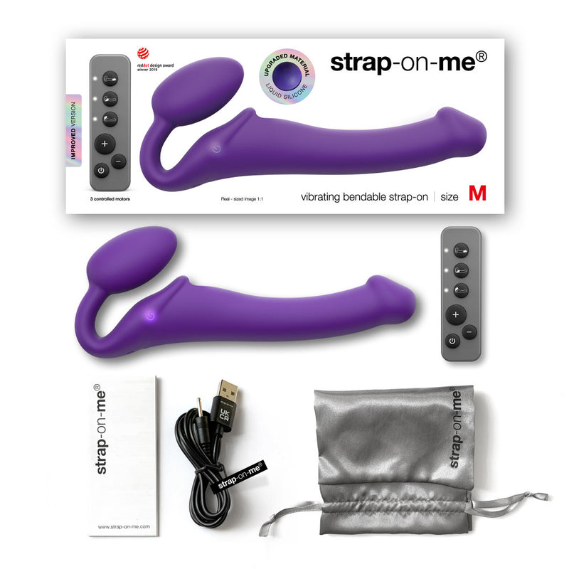 The Strap-On-Me Vibrating Bendable Strapless Strap-On shown with everything it comes with including the external box. The set includes the vibrator itself, the remote, the instruction, a charging cable, and a gray satin drawstring storage bag. | Kinkly Shop