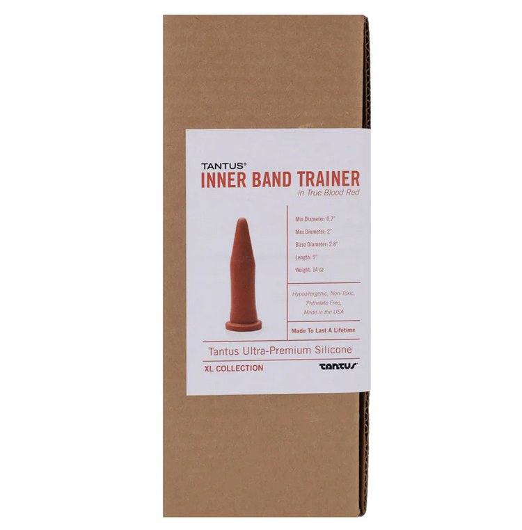 Packaging of the Tantus Inner Band Trainer dildo. It comes in a plain brown, recyclable cardboard box with a sticker that showcases the features of the Tantus Inner Band Trainer. | Kinkly Shop