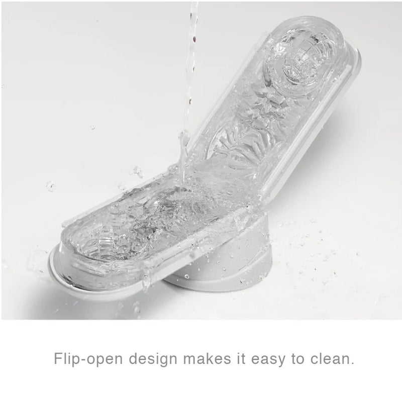 The Tenga Flip Zero opened up while water pours on top of the open texture, splashing everywhere, showcasing how simple it is to clean. The text on the image reads "Flip-open design makes it easy to clean" | Kinkly Shop