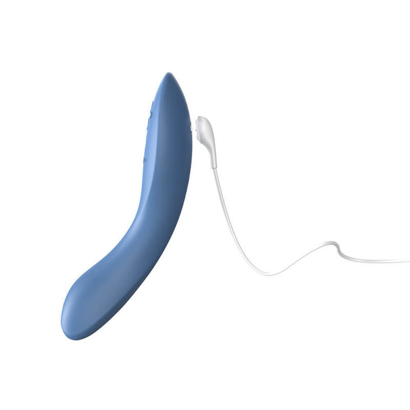 The We-Vibe Rave 2 up against a white background with the magnetic charging cable hovering over the two magnetic ports. | Kinkly Shop