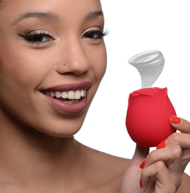 A person holds the XR Bloomgasm Rose near her face, smiling at the camera. An illustrated tornado is shown coming out the tip of the XR Bloomgasm Rose, showcasing the air suction functionality of the vibrator. | Kinkly Shop