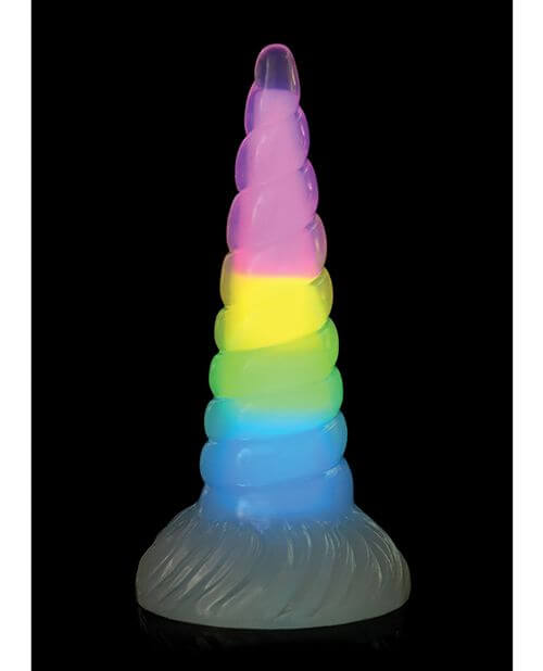 The Creature Cocks Uni Glow in front of a plain black background. The Glow-in-the-Dark pigment is glowing strongly, showcasing a pastel rainbow color throughout the entire interior length of the dildo. | Kinkly Shop