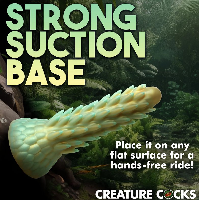 The Creative Cocks Stegosaurus is shown pretending to suction cup to a tree within a forest. Text on the image reads: "Strong suction base. Place it on any flat surface for a hands-free ride!" | Kinkly Shop