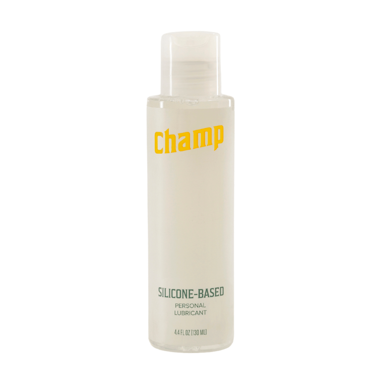 Bottle of the Champ Silicone-Based Lube - 4.4OZ. The bottle features a pop top lid. It's a plastic bottle that's primarily white in color. The text on the bottle reads "Champ. Silicone-based personal lubricant. 4.4 fl oz." It is a very unassuming-looking bottle. | Kinkly Shop