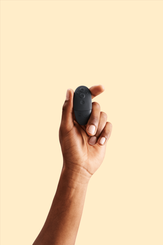 A hand holding the remote to the We-Vibe Bond. It shows that the remote is about the size of the person's thumb, and it easily could hide inside a closed fist. | Kinkly Shop