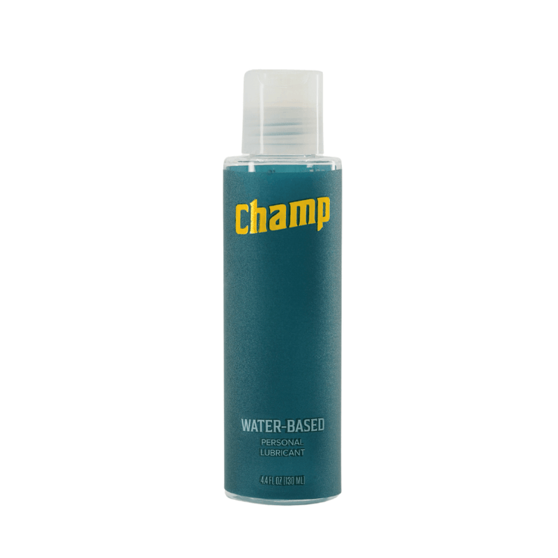 Bottle of the Champ Water-Based Lube - 4.4OZ sitting against a white background. The bottle is a plastic bottle with a pop-top cap. The bottle's label is a deep teal color with the text "Champ" in gold on the front. It also says "Water-based personal lubricant" but it is otherwise very unassuming to look at for discretion. | Kinkly Shop