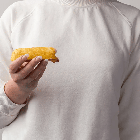 GIF of a person holding a Twinkie. Another person inserts a can of whipped cream and squeezes it in. The person holding the Twinkie then inserts a Awkward Essentials Dripsticks to showcase how it absorbs and removes the whipped cream. | Kinkly Shop