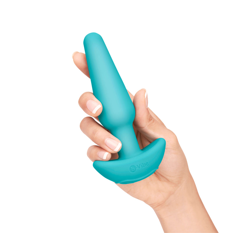 A hand holds the the Medium butt plug in their hand up against a white background. | Kinkly Shop