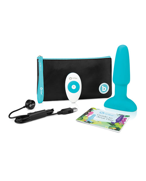 The b-Vibe Rimming Plug 2 with everything that it comes with. This includes the plug itself, the remote, the Guide to Anal Play, the charging cable, and a branded zippered pouch to store it all in. | Kinkly Shop