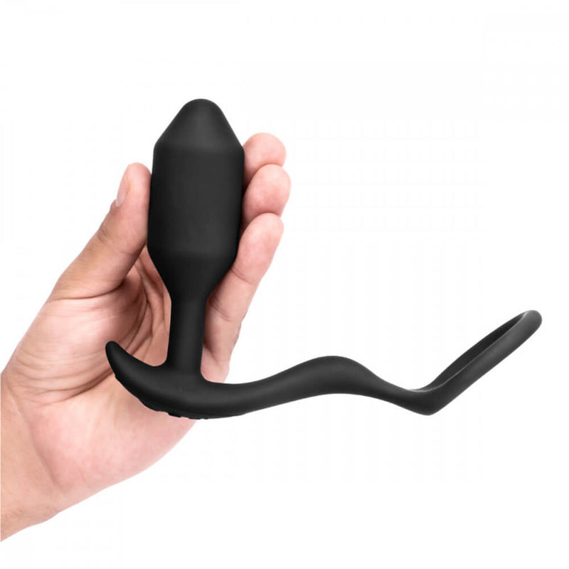 A hand holds the b-Vibe Vibrating Snug and Tug in Medium. It's a torpedo-shaped plug that's slightly thinner than 3 fingers in diameter. | Kinkly Shop