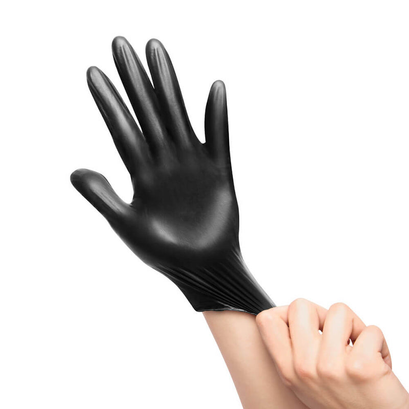 A person uses both of their hands to stretch one of the included black, disposable gloves onto their hand from the b-Vibe mASSter's Degree Anal Set. | Kinkly Shop'
