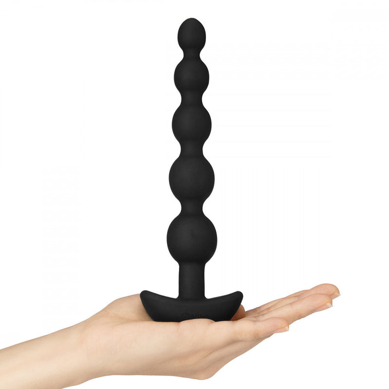 A hand holding the b-Vibe Cinco Remote Control Rechargeable Beads to display its height. | Kinkly Shop