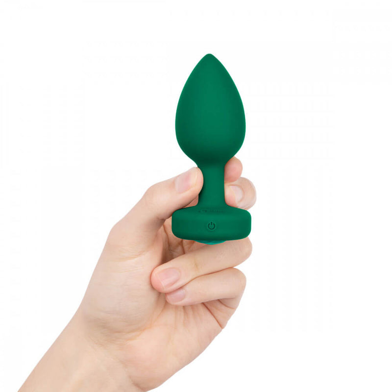 A person holds the b-Vibe Vibrating Jewel Remote Control Butt Plug at the retention neck of the plug. | Kinkly Shop
