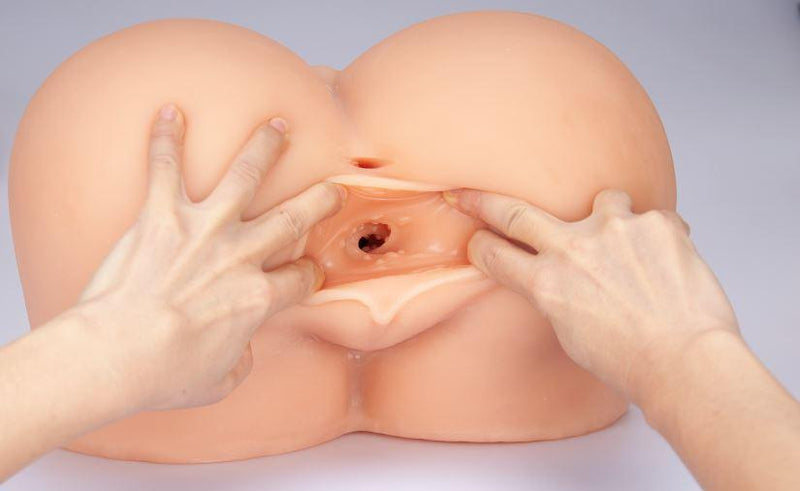 A person uses both hands to widely spread the vaginal tunnel on the Cloud 9 Life-Size Portable Sex Doll. This shows how large the portable sex doll is compared to two hands (it's much much larger) in addition to showing the nubbed texturing that's found throughout the vaginal canal. | Kinkly Shop