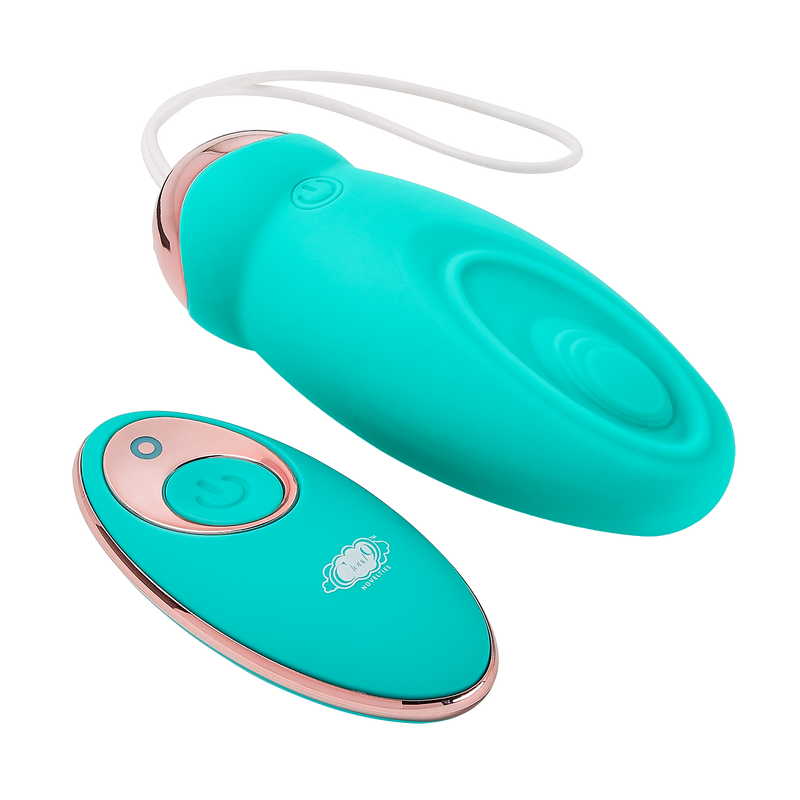Pulsating version of the Cloud 9 Wireless Remote Control Eggs laying next to its remote control. The Pulsating version has a wave-like divet on one side of the toy where a small area "pulses" in and out from the toy when turned on | Kinkly Shop
