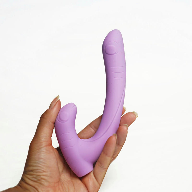 A hand holds the Cute Little Fuckers Jix. This gives a good idea about the vibe's size. The "handle" portion is about as long as the person's palm to the end of their thumb while the "shaft" of the Jix is clearly much longer than the person's hand. The thickness looks slightly thicker than a finger but not as thick as two fingers. | Kinkly Shop