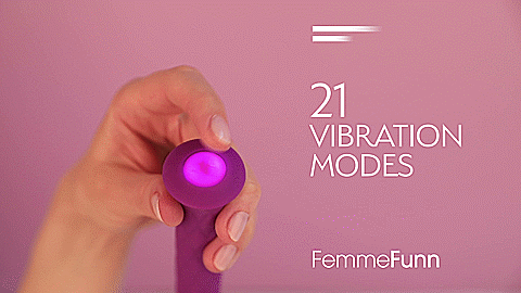 GIF showing a single hand holding the FemmeFunn Diamond Wand with the base facing the camera. This showcases the large, single, backlit button on the base of the vibrator. The finger presses down the button to change the vibration modes. Text on the GIF reads "21 Vibration Modes. FemmeFunn" | Kinkly Shop