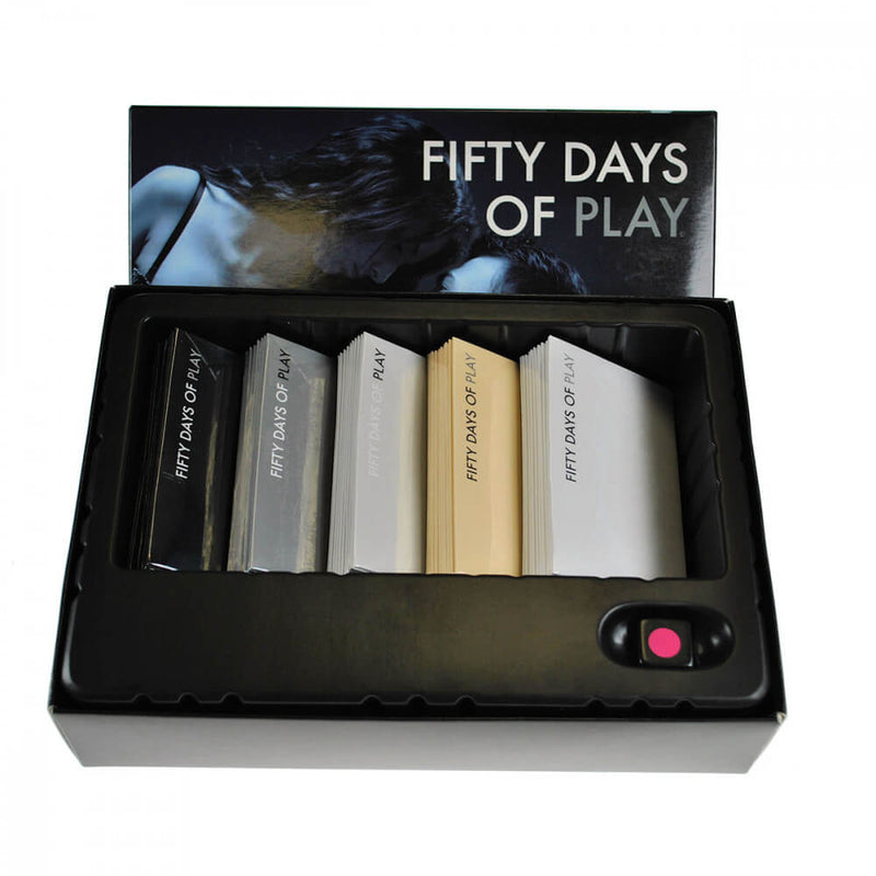 The inside of the box of the Fifty Days of Play Bondage game. All of the fifty tasks are separated by color and sitting nicely in a plastic tray. The included die has a special spot it fits into to the side of the cards. | Kinkly Shop