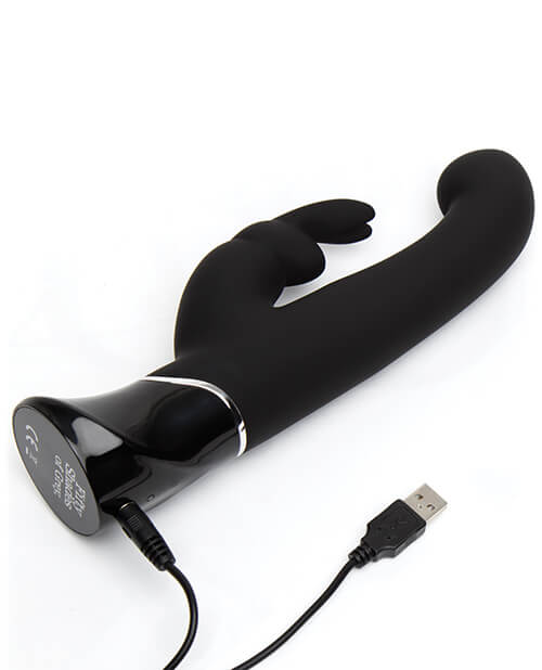 The Fifty Shades of Grey Greedy Girl Rabbit Vibrator lays flat while the charging cable is plugged into the back-end of the vibrator to show how it charges. | Kinkly Shop