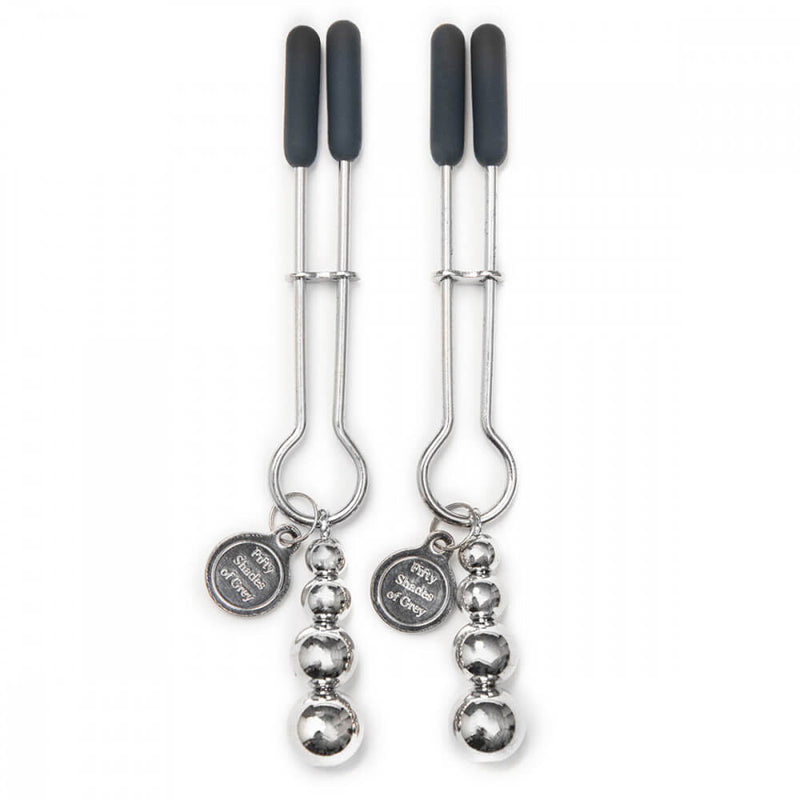The Fifty Shades of Grey Pinch Nipple Clamps laying flat. This showcases the sliding tightness piece as well as the charm and weighted beads hanging off each one of the nipple clamps. | Kinkly Shop