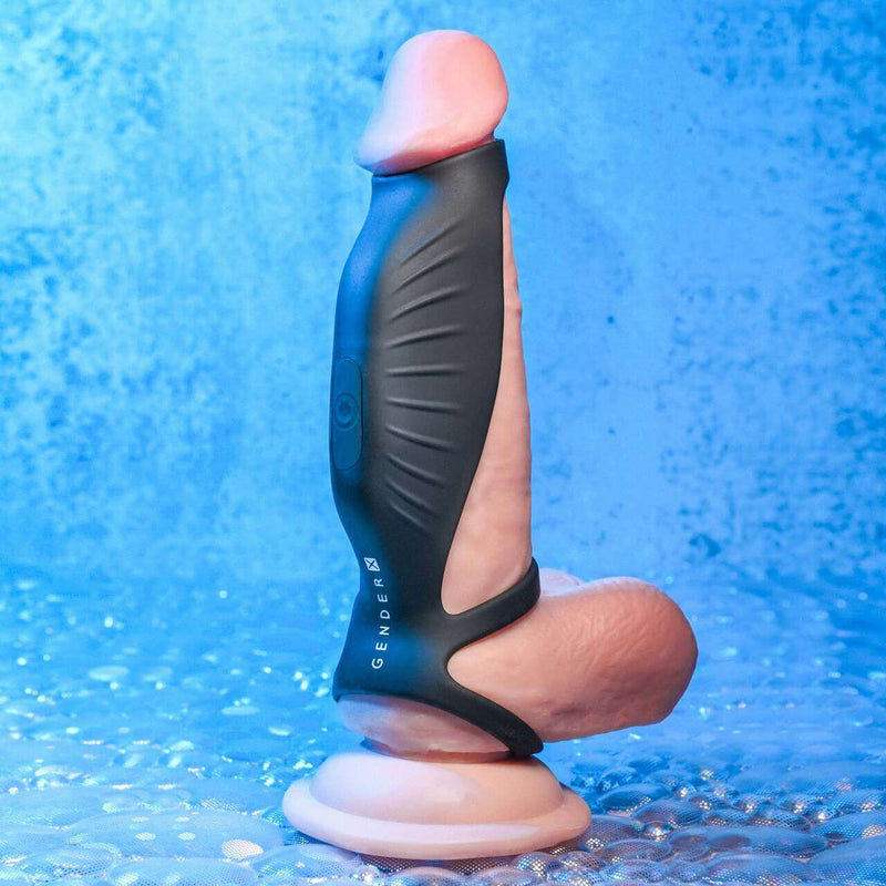 Gender X Rocketeer being worn on a realistic dildo against a bright blue background. This angle showcases the tight fit the Gender X Rocketeer has along an erection as well as its length-dependent fit. It is designed for the tip to rest right underneath the head of the shaft. This angle also showcases the added thickness of the vibration portion when the toy is used with penetration. | Kinkly Shop