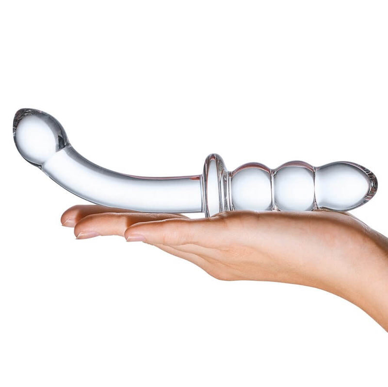 A hand holds the 8" Glass Ribbed G-Spot dildo with the palm laying flat and the dildo presented on top. The dildo is slightly thicker than a finger, but it is much longer than the open palm. | Kinkly Shop