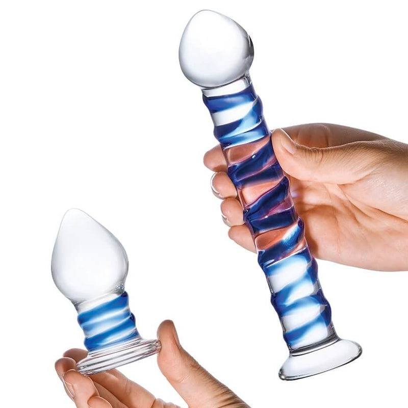 Two hands hold both items from the Glas Double Penetration Kit. One hand has the butt plug while the other hand holds the dildo. | Kinkly Shop