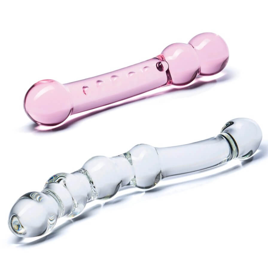 Both of the GLAS Double Pleasure Set dildos laying out. This view showcases the light pink - but still transculent - view of the pink dildo and the see-through design of the clear dildo. | Kinkly Shop