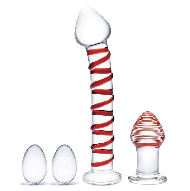 The 4-piece Glas Double Penetration Kit called the Mr. Swirly set. All four toes sit in front of a white background. The dildo and butt plug have red swirls while the two kegel eggs are clear glass with no design. | Kinkly Shop