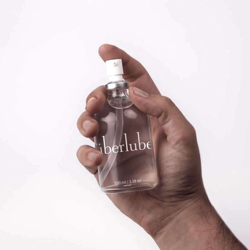 A 100ml bottle of Überlube premium silicone sex lube being held in a hand | Kinkly Shop