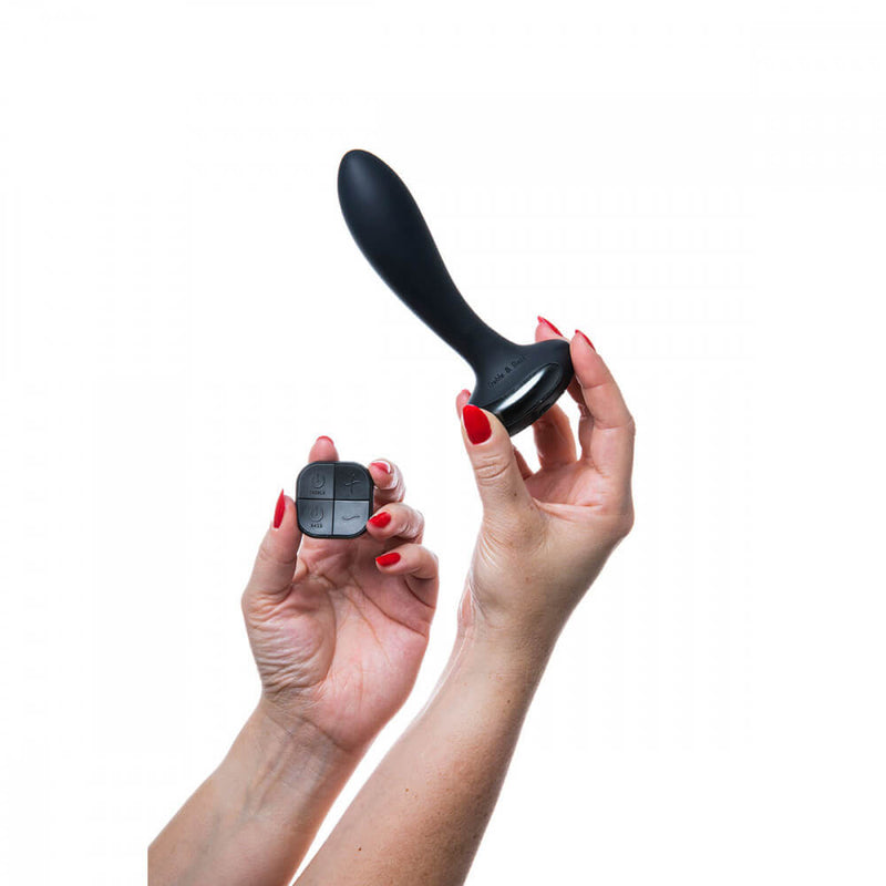 Two hands are holding the Hot Octopuss PleX with Flex toy. One hand holds the insertable plug while the hand next to it holds the remote control for the Hot Octopuss PleX with Flex. | Kinkly Shop