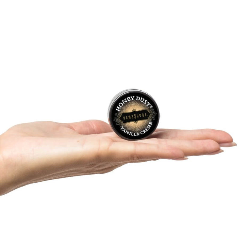 A flat palm showcases the Honey Dust size included in the Kama Sutra Getaway Kit. It's about the size of a lip balm that's applied with the fingers. | Kinkly Shop