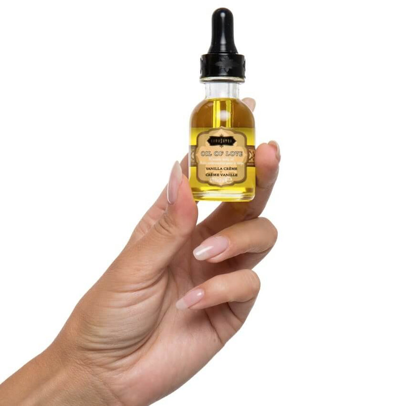 A hand holds the Oil of Love bottle included within the Kama Sutra Getaway Kit. | Kinkly Shop