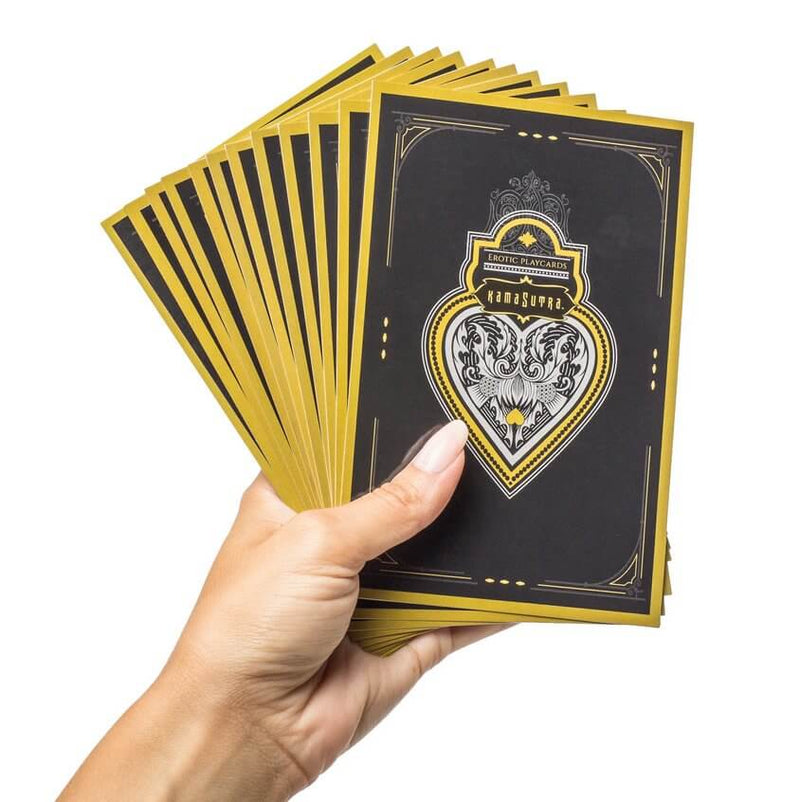 A person holds the Erotic Playcards from the Kama Sutra Trust Me Erotic Playset. These are the backside of the cards, and they're in a black and yellow coloration. They are surprisingly huge, and they are noticeably large - about the size of the person's outstretched hand or slightly larger. | Kinkly Shop