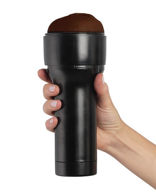 KIIROO RealFeel Generic Vulva in Dark Brown. A hand is wrapped around the base of the stroker. The casing of the stroker offers a lot of space for the hand to rest, and it keeps it away from the internal stroker and the lube. | Kinkly Shop