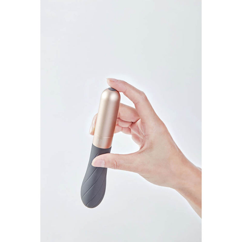 A hand holds the Love Not War Grá. The vibrator looks slightly longer than a hand, but it comfortably fits between the fingers. | Kinkly Shop