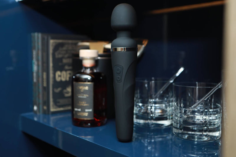 The Domi 2 sits upright on a fancy-looking shelf next to two cocktail glasses. | Kinkly Shop