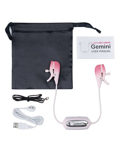 Everything included with the Lovense Gemini remote control nipple clamps laid out on a white surface. The image shows a black drawstring bag, the user manual, the necklace, the bra clip, the charging cable, and the Gemini itself. | Kinkly Shop