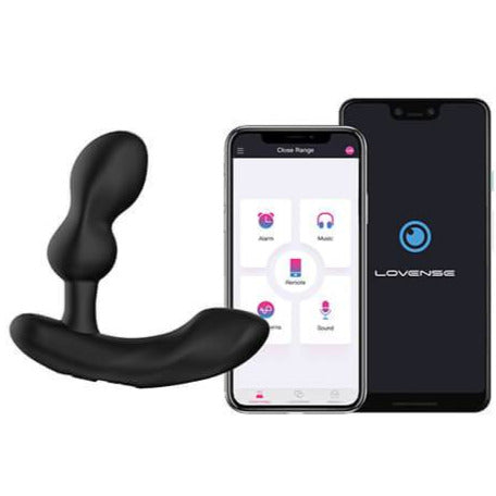 The Lovense Edge 2 sits next to a cell phone. The cell phone is opened to the Lovense app that allows the user to control the functionality of the Lovense Edge 2. | Kinkly Shop