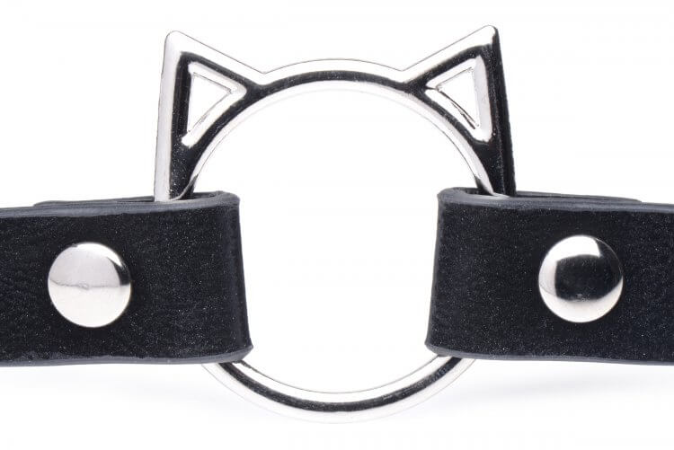 Close-up of the hardware on the front of the Master Series Slim Kinky Kitty Ring Choker. It is a round, metal ring with two triangles (ears) attached to the top corners to look like a kitty face. | Kinkly Shop