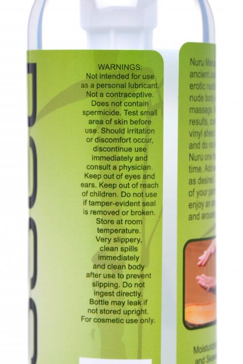 Warnings included on the Nuru Couple's Body Massage Gel bottle. Text reads "Not intended for use as a personal lubricant. Not a contraceptive. Does not contain spermicide. Test small area of skin before use. Should irritation occur, discontinue use immediately and consult a physician. Keep out of eyes and ears. Keep out of reach of children. [...] Store at room temperature. Very slippery, clean spills immediately...." | Kinkly Shop