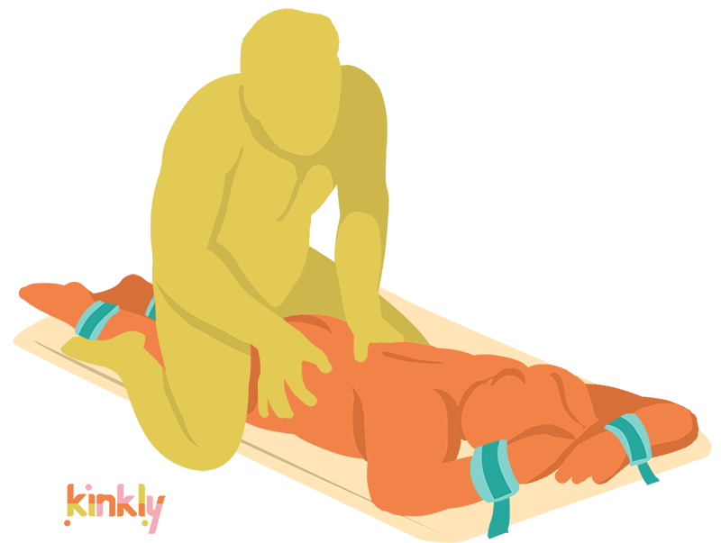 An illustrated sex position. The Bondi is laid flat, and the receiving partner is laying, length-wise, with their wrists and their ankles bound. The penetrating partner is straddling the receiving partner's hips from behind as they grip the receiving partner's lower back. | Kinkly Shop