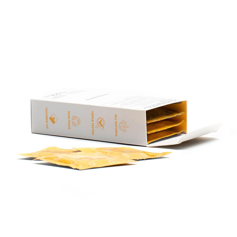 The Royal Tailored Fit Ultra Thin Vegan Latex Condoms - 10 Pack box is open, showcasing the yellow, individually-wrapped condoms inside. The box has the words "Triple tested. Non-toxic. Tailored fit. All natural" written on it. | Kinkly Shop
