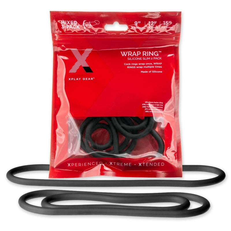 The packaging for the Perfect Fit Slim Wrap Cock Rings sits out. In front of it, a separate set of the three included wrap cock rings are sitting out. | Kinkly Shop