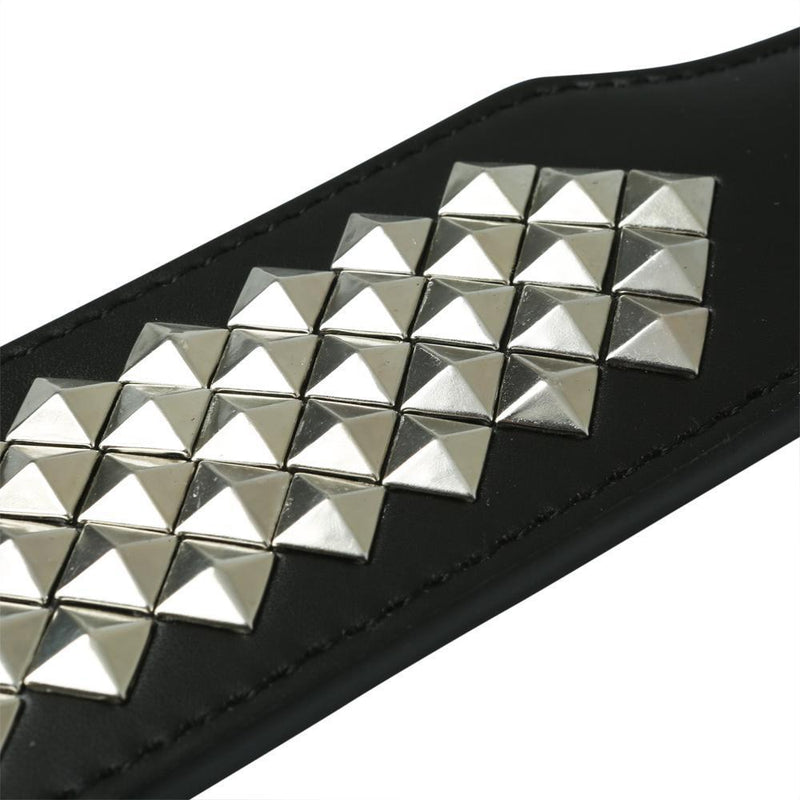 Close-up of the textured pyramids that are found on one entire side of the Sportsheets Studded Paddle. It shows that they are raised triangles against the flat, smooth surface of the vinyl spanking paddle. | Kinkly Shop