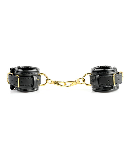 The two cuffs of the Sportsheets Cuffs and Blindfold Set are fastened shut and resting in a circular shape. The two, attached, golden connectors are attached to one another, binding the two cuffs to one another with no additional hardware. | Kinkly Shop