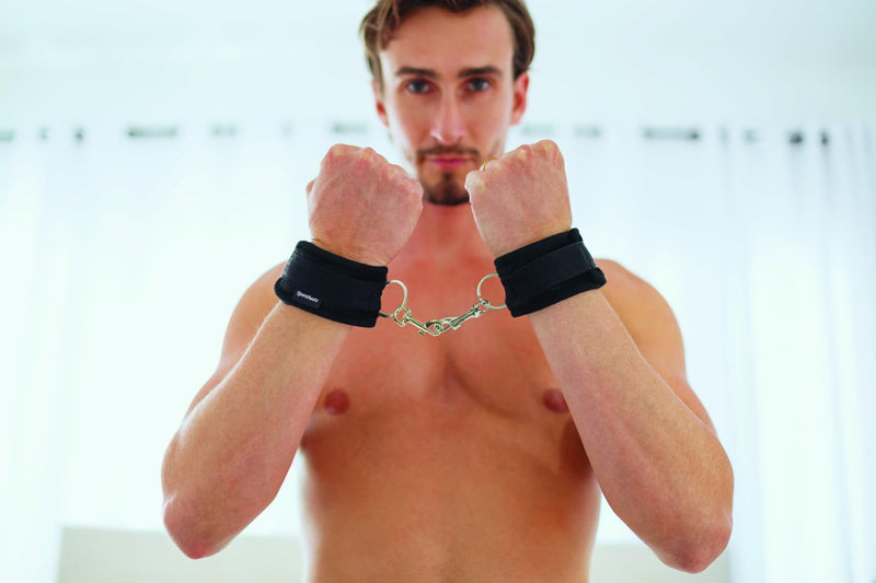 A muscular person presents their forearms straight to the camera. The Sportsheets Soft Wrist Cuffs are wrapped around their wrists and connecting their two arms together. | Kinkly Shop
